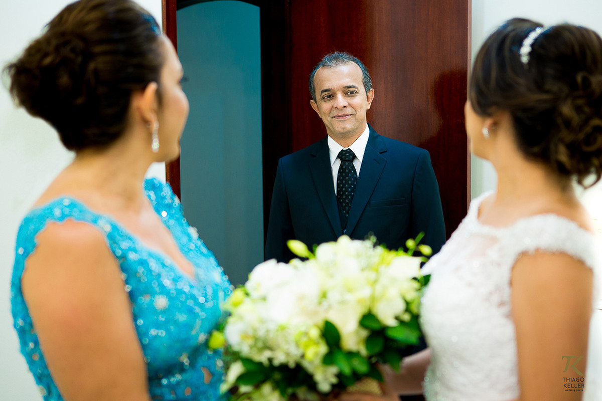 Foto antes do casamento com a mãe e o pai da noiva tendo o primeiro encontro com a filha já vestida para o casamento.