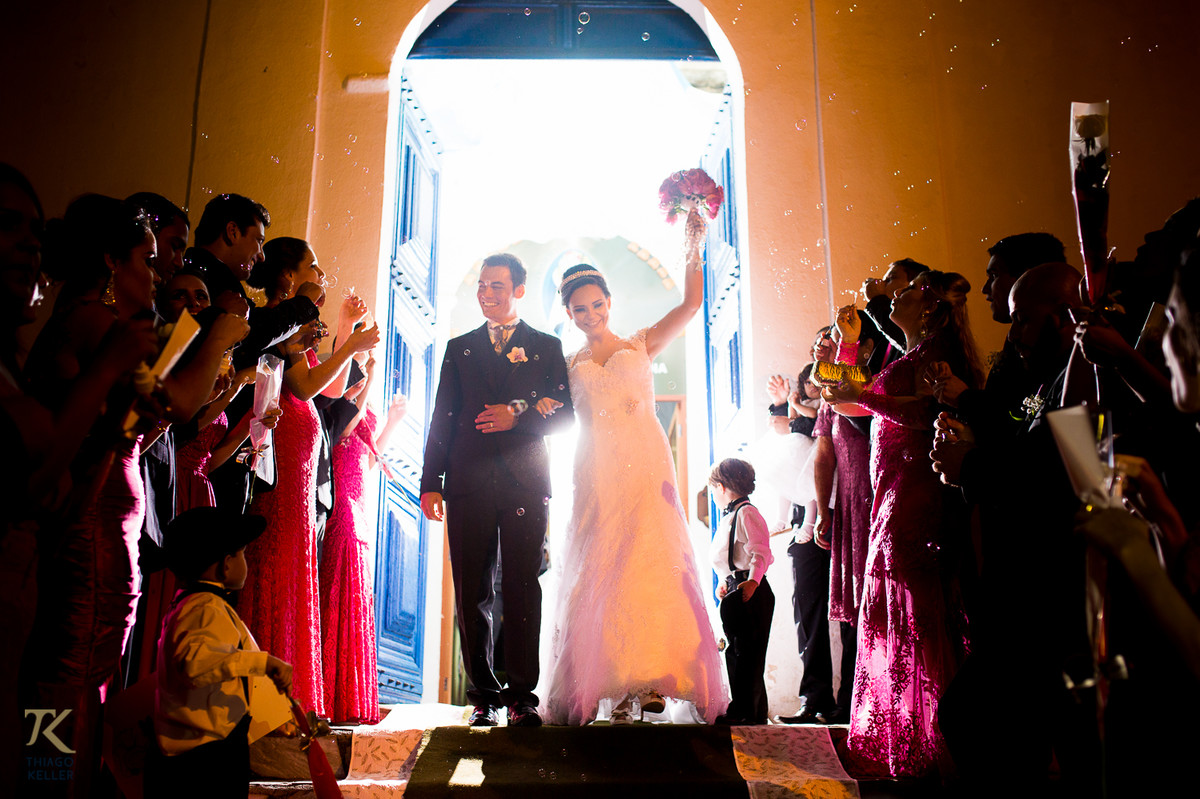 Casamento de Sabrina e Alisson. Noivos saem da Igreja comemorando.