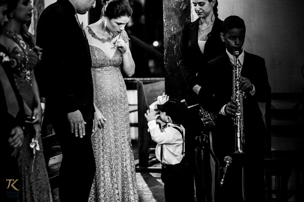 Casamento de Sabrina e Alisson. Uma das madrinhas faz sinal de silêncio para o pajem.