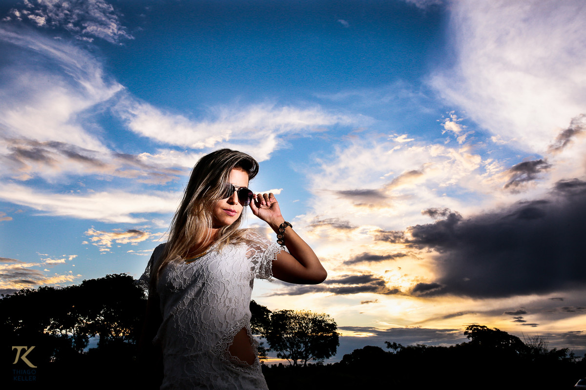 ensaio fotográfico book de Jackeline Marins realizado na cidade de Paracatu, Minas Gerais com a modelo vestindo um macacão branco e posicionada contra luz.