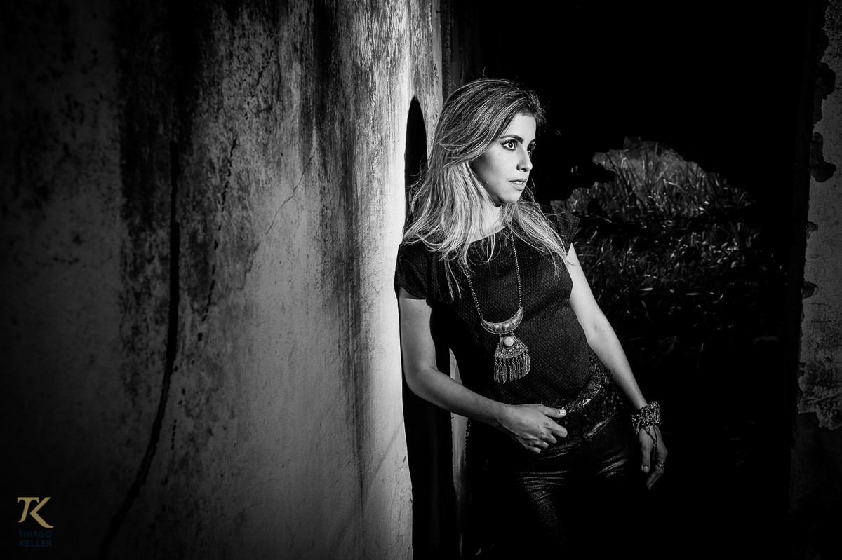 ensaio fotográfico book de Jackeline Marins realizado na cidade de Paracatu, Minas Gerais com a modelo apoiada em uma parede. Foto preto e branco.