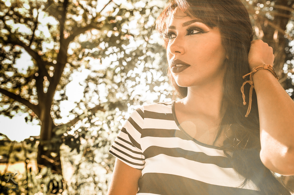Book de fotografia de Jadla realizado na cidade de Paracatu, Minas Gerais, em posto abandonado. A modelo está contra luz com uma árvore ao fundo.