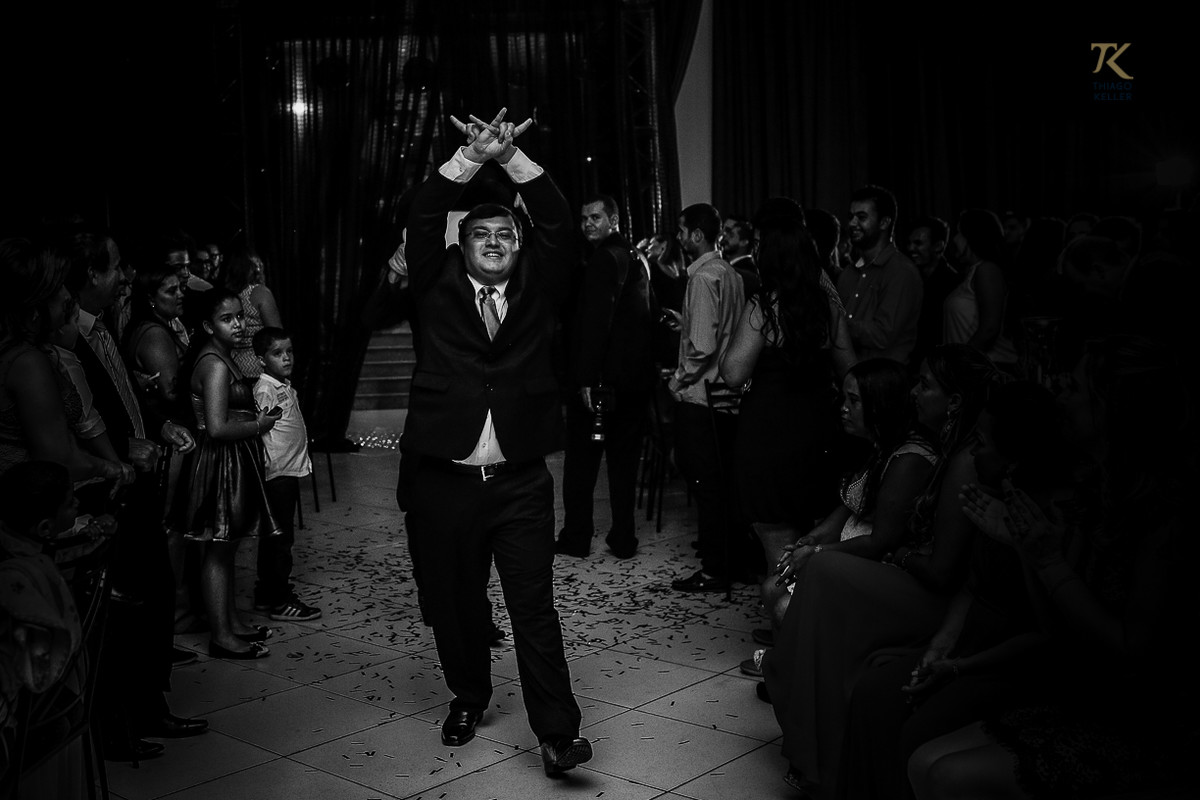 Foto de formatura realizada na cidade de Cristalina, Goias. Formando fazendo o sinal do metal. Foto em preto e branco.