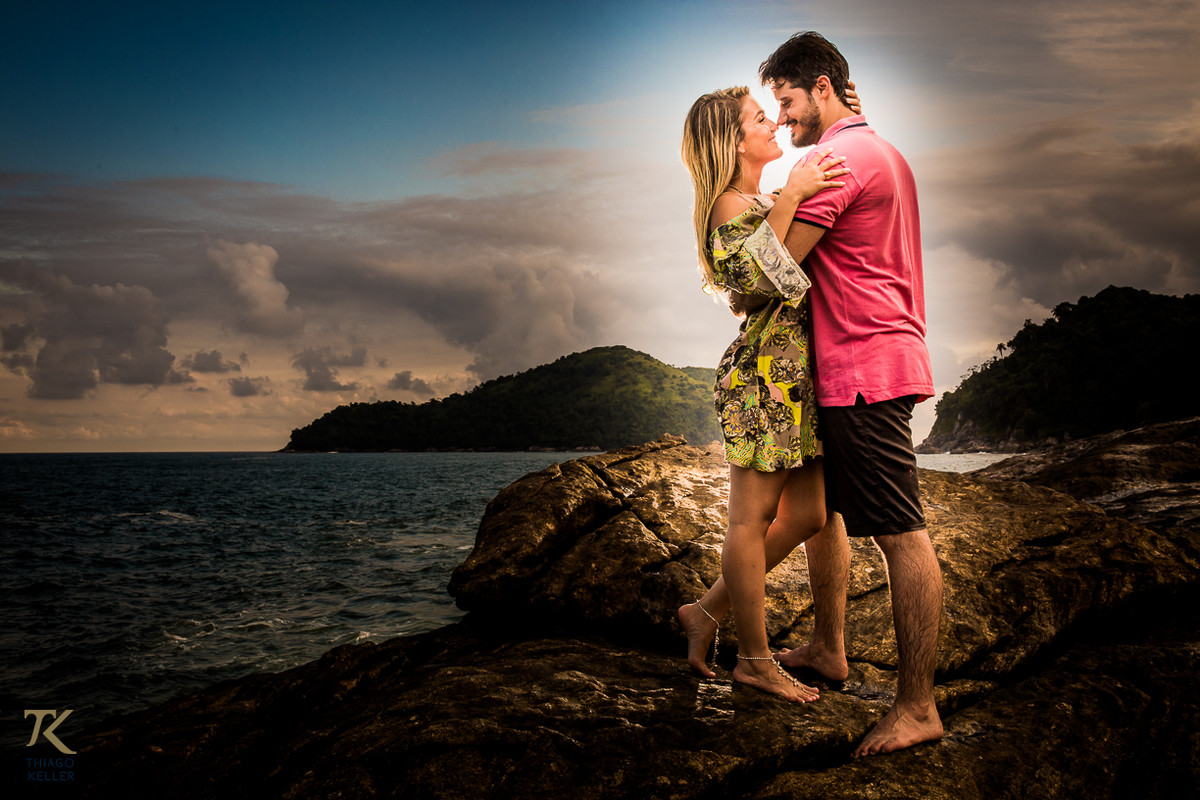 Casal abraçado em cima de uma pedra na praia do Balneário de Maresias em São Paulo.