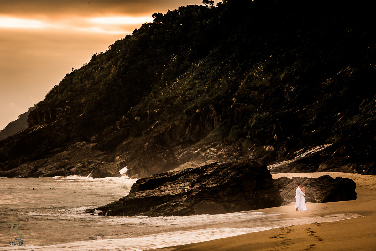 Casal abraçado emoldurado pela natureza em Maresias