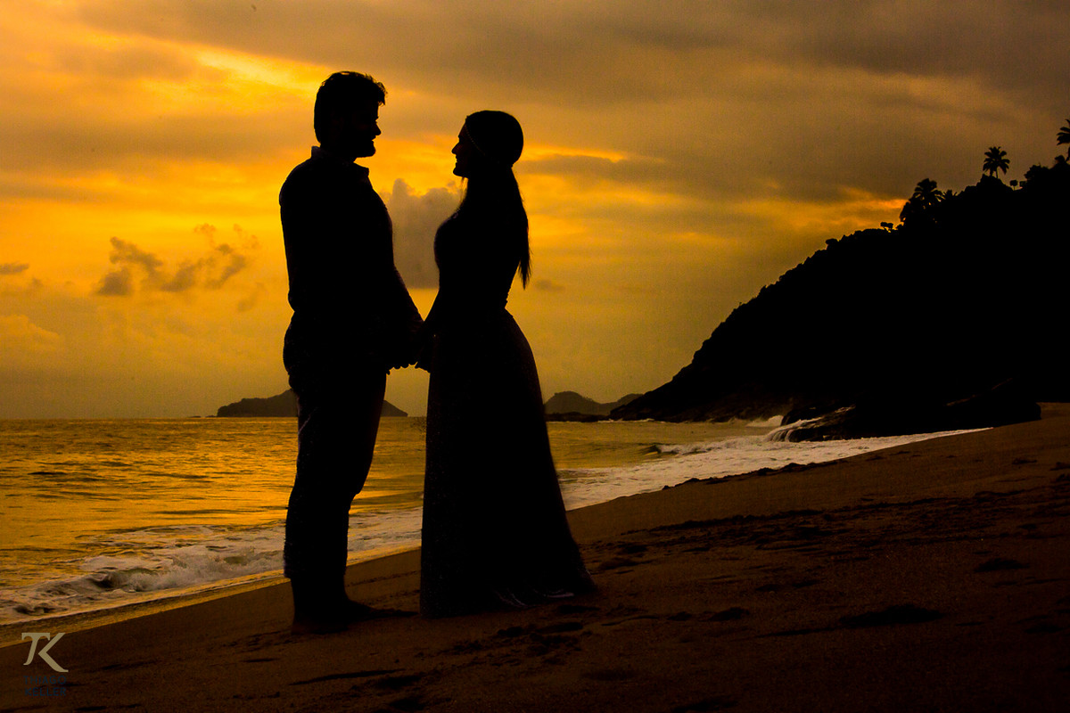 Casal apaixonado durante o por do sol na praia no Balneário de Maresias em São Paulo