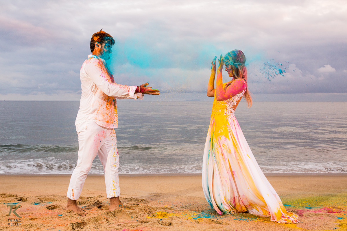 Casal brinca com pó colorido em um festival de cores.