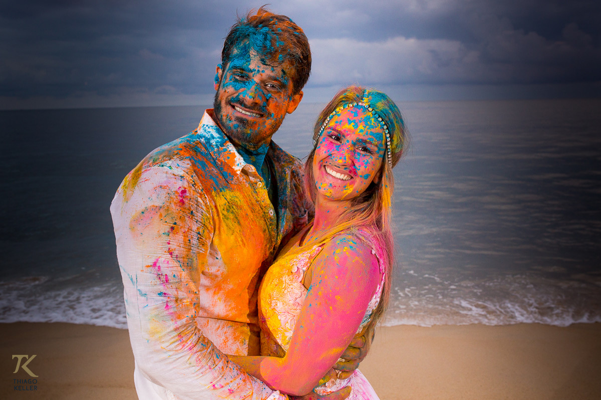 Casal brinca com pó colorido em um festival de cores.
