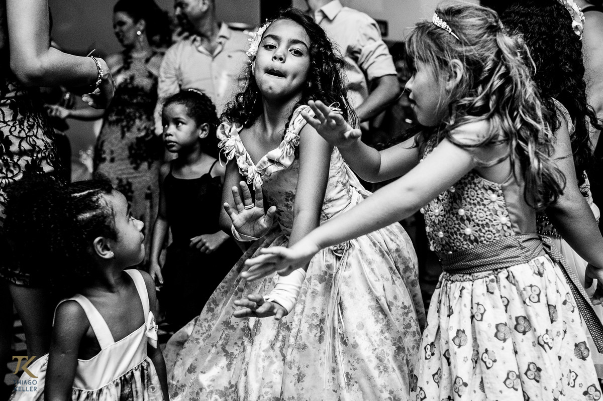 Fotografia de casamento de Lívia e Paulo Henrique na cidade de Paracatu, Minas Gerais. Crianças aproveitam a pista de dança. Foto em preto e branco.