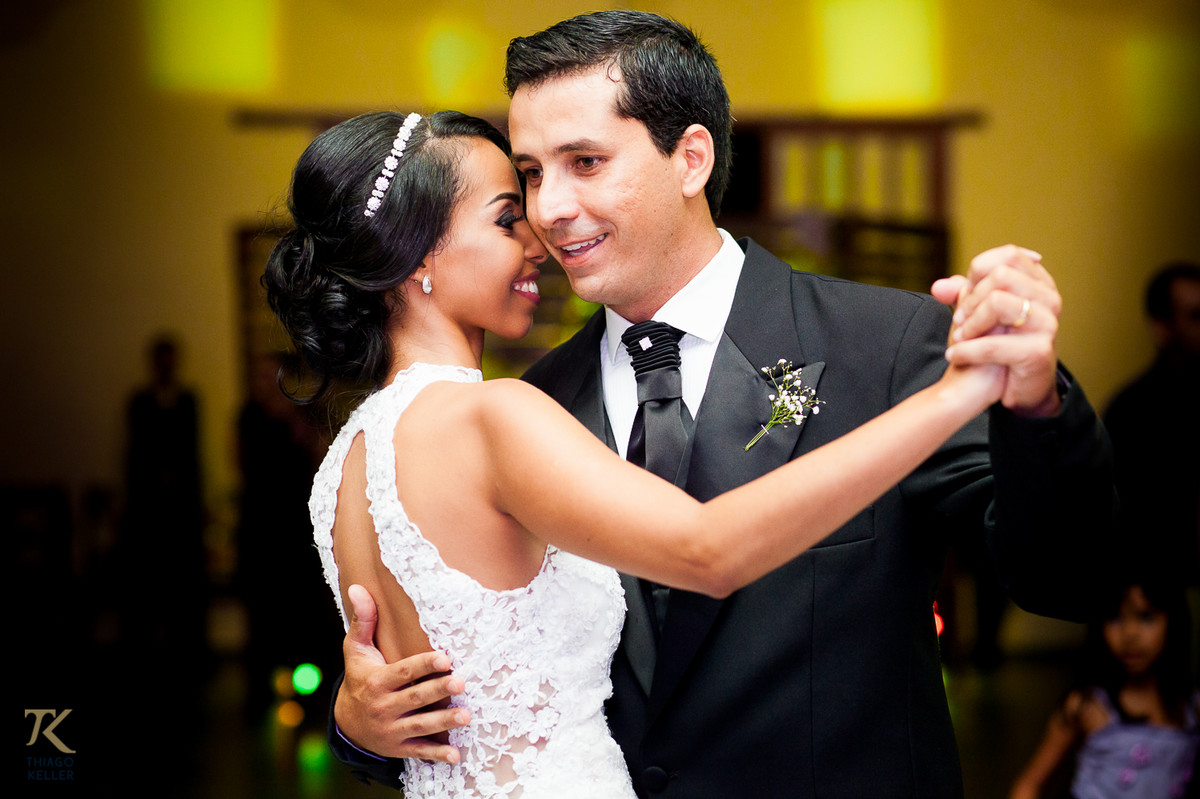 Fotografia de Casamento de Maura e Thiago realizado na cidade de Paracatu, Minas Gerais. Casal dança sorridente pela primeira vez como casados.
