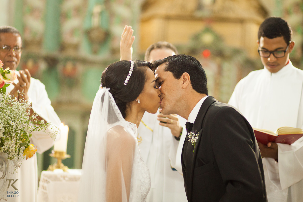 Fotografia de Casamento de Maura e Thiago realizado na cidade de Paracatu, Minas Gerais. Noivo beija a noiva.
