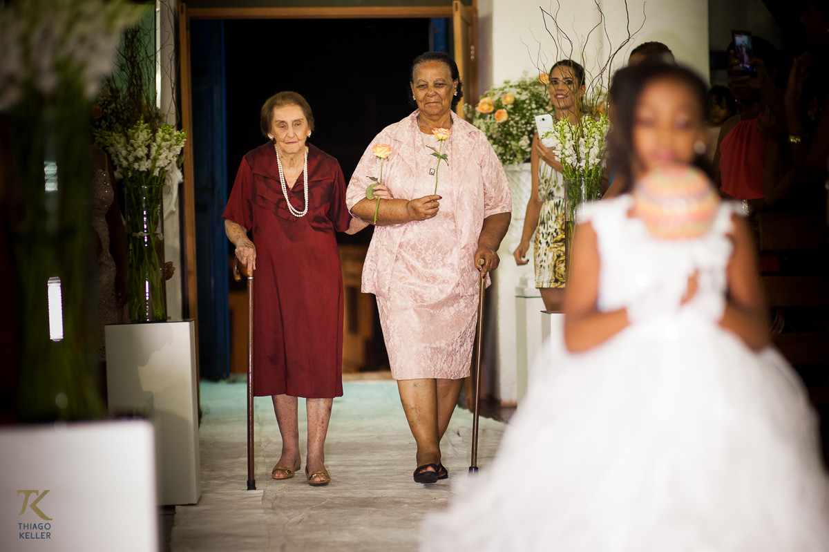 Fotografia de Casamento de Maura e Thiago realizado na cidade de Paracatu, Minas Gerais.  Avós dos noivos entram durante a cerimônia.