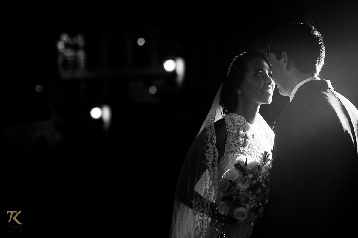 Fotografia de Casamento de Maura e Thiago realizado na cidade de Paracatu, Minas Gerais. Noivos se olham apaixonados no Largo da Jaqueira. Foto em preto e branco.