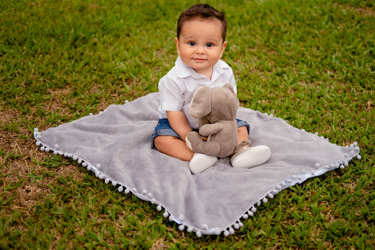 Bebê olhando pra câmera com o deu elefante