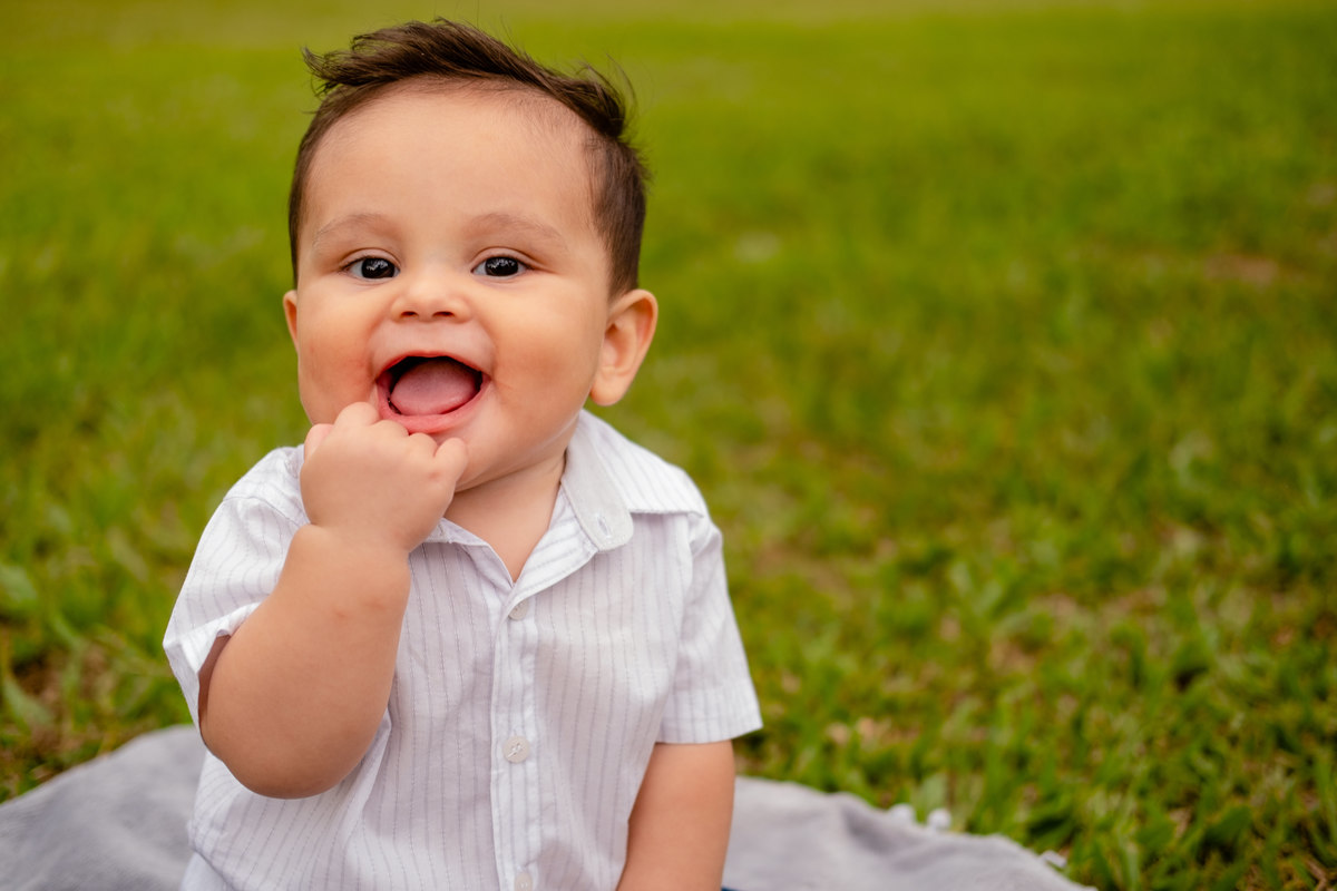 Bebê com a mão na boca sorrindo