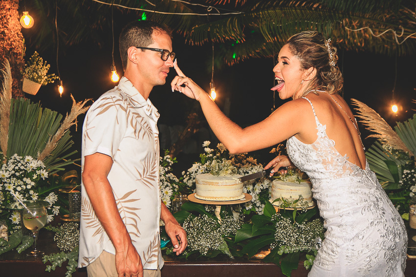 noivo-e-noiva-felizes-na-mesa-do-bolo
