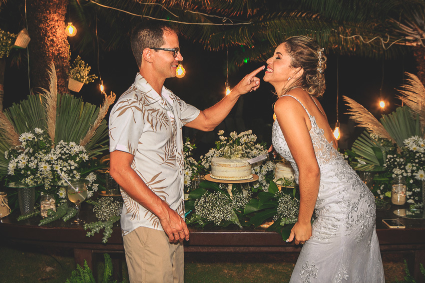 fotografia-dos-noivos-brincando-na-mesa-do-bolo