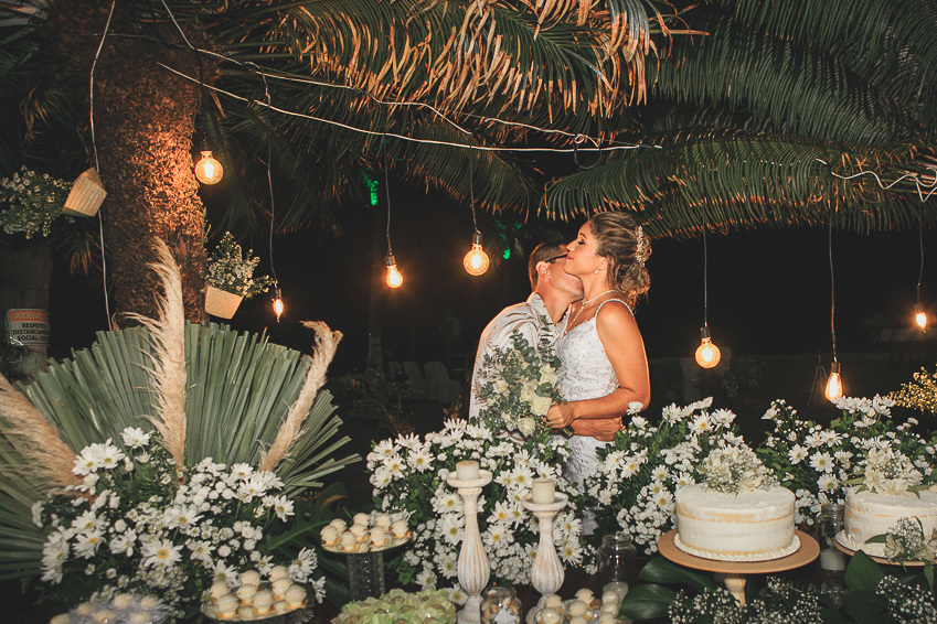 noiva-e-noivo-se-beijam-na-mesa-do-bolo