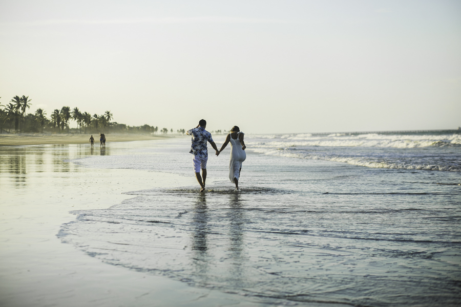 noivo  e noiva andando de mãos dadas na praia do cumbuco