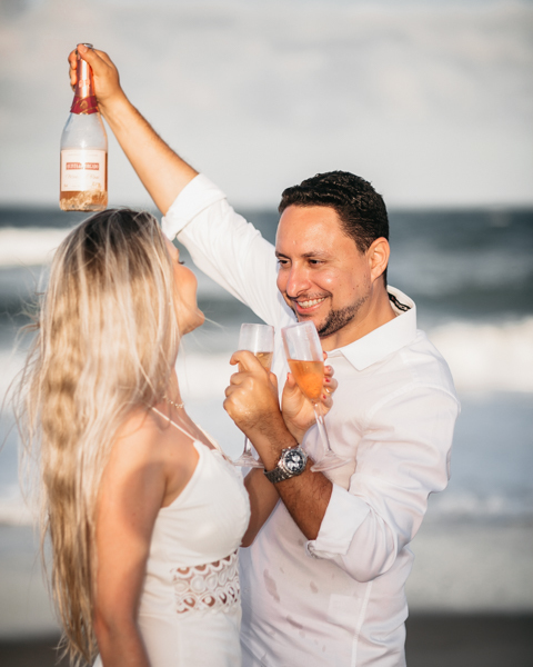 NOIVO COM CAMISA BRANCA E CALÇA BEGE NUM ENSAIO PRE WEDDING NA SESSÃO EXTERNA NO POR DO SOL DA PRAIA DO BEACH PARK EM AQUIRAZ BRINDARAM A FELICIDADE DO CASAL JA PROXIMO DO SEU CASAMENTO