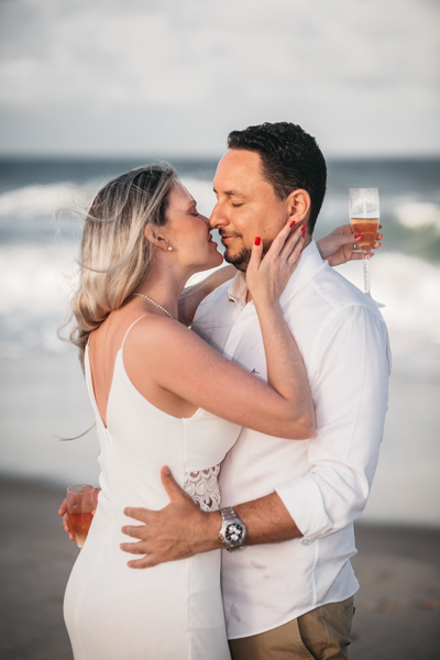 NOIVO COM CAMISA BRANCA E CALÇA BEGE NUM ENSAIO PRE WEDDING NA SESSÃO EXTERNA NO POR DO SOL DA PRAIA DO BEACH PARK EM AQUIRAZ BRINDARAM A FELICIDADE DO CASAL JA PROXIMO DO SEU CASAMENTO
