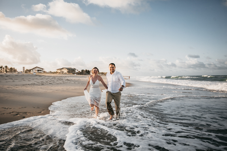 NOIVOS CAMINHANDO NA PRAIA NUMA SESSÃO EXTERNA DE FOTOGRAFIA NO SEU PRE WEDDING AO POR DO SOL NA PRAIA DO BEACH PARK EM AQUIRAZ MUNICIPIO DE FORTALEZA CEARA