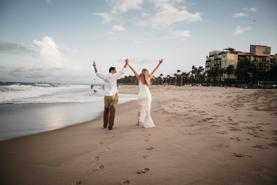 NOIVOS CAMINHANDO NA PRAIA NUMA SESSÃO EXTERNA DE FOTOGRAFIA NO SEU PRE WEDDING AO POR DO SOL NA PRAIA DO BEACH PARK EM AQUIRAZ MUNICIPIO DE FORTALEZA CEARA