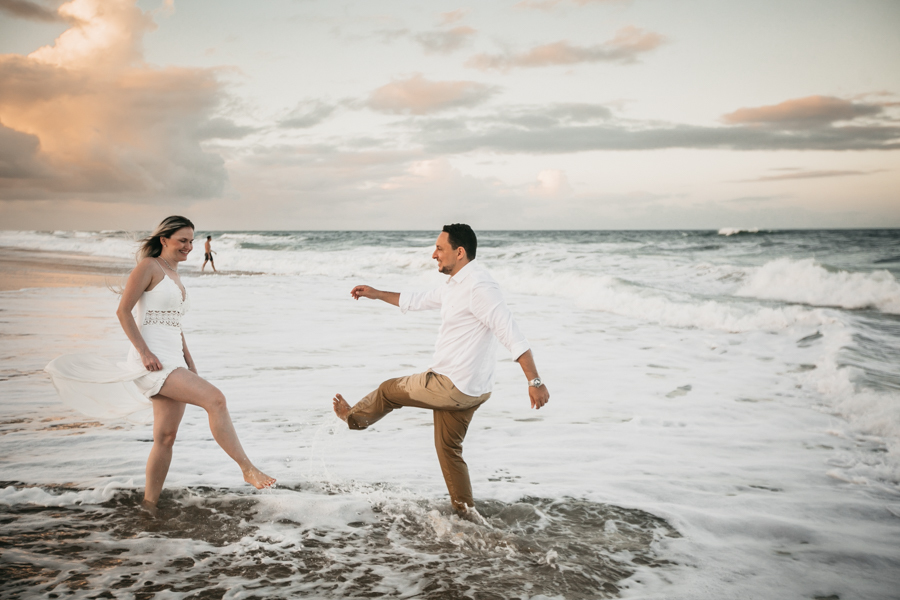 NOIVOS CAMINHANDO NA PRAIA NUMA SESSÃO EXTERNA DE FOTOGRAFIA NO SEU PRE WEDDING AO POR DO SOL NA PRAIA DO BEACH PARK EM AQUIRAZ MUNICIPIO DE FORTALEZA CEARA