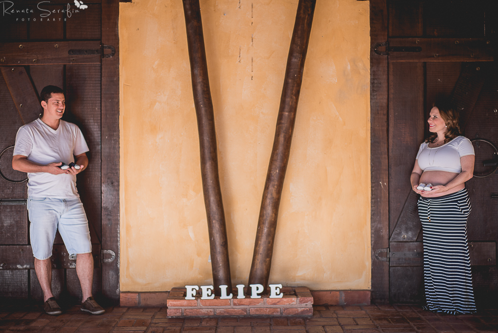 papai e mamãe segurando o sapatinho no ensaio de gestante feito pela fotógrafa de recem nascido Renata Serafim