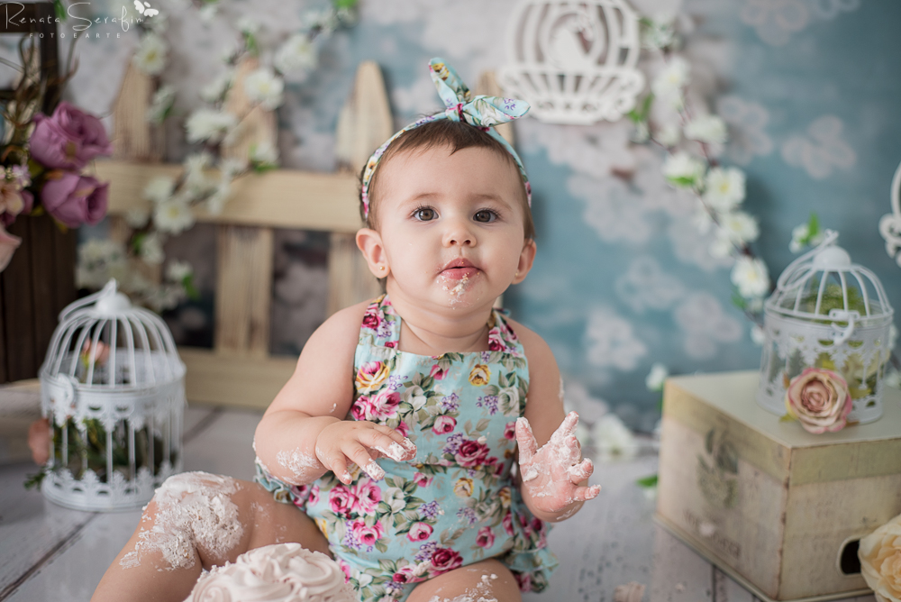 Menina comendo bolo na sessao smash the cake em jau