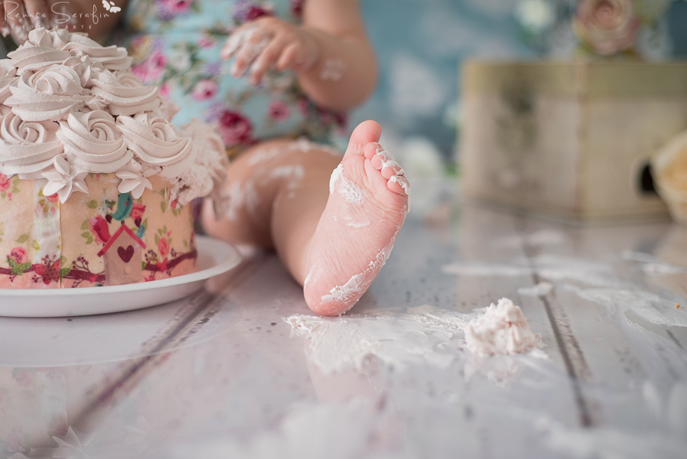 Menina comendo bolo na sessao smash the cake em jau