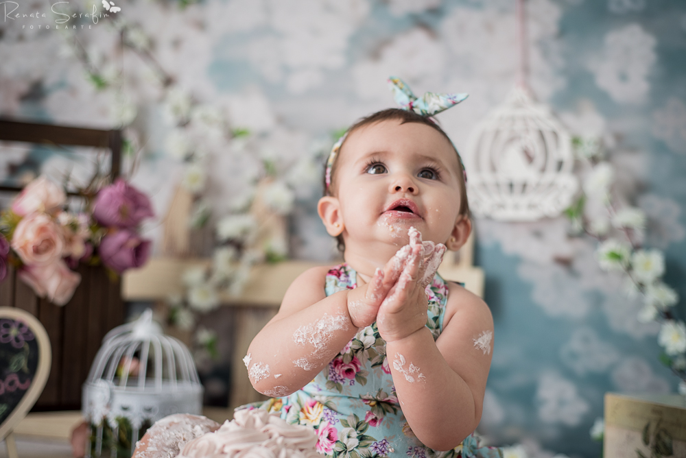 Menina comendo bolo na sessao smash the cake em jau