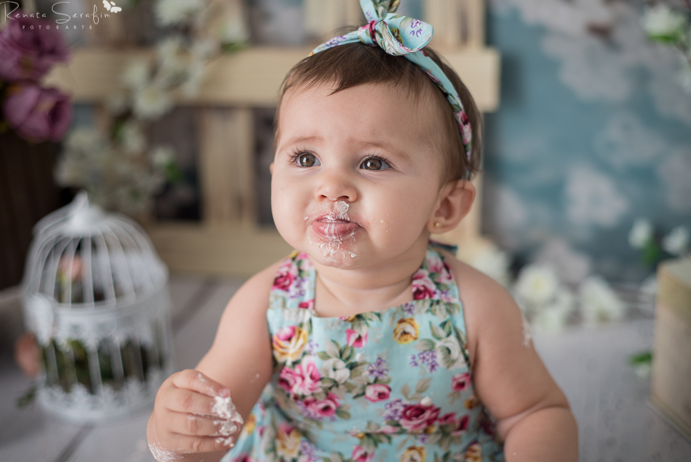 Menina comendo bolo na sessao smash the cake em jau