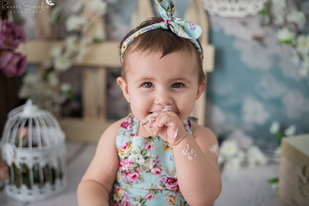 foto de Menina comendo bolo na sessao smash the cake em jau