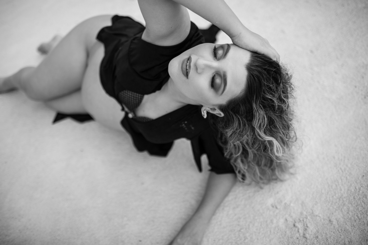 Outra imagem da gestante deitada, desta vez com um foco mais próximo. A pose e o olhar dela para a câmera evocam confiança e beleza. Fotos feitas pelo fotógrafo de gestante Rafael Ohana em Brasília.