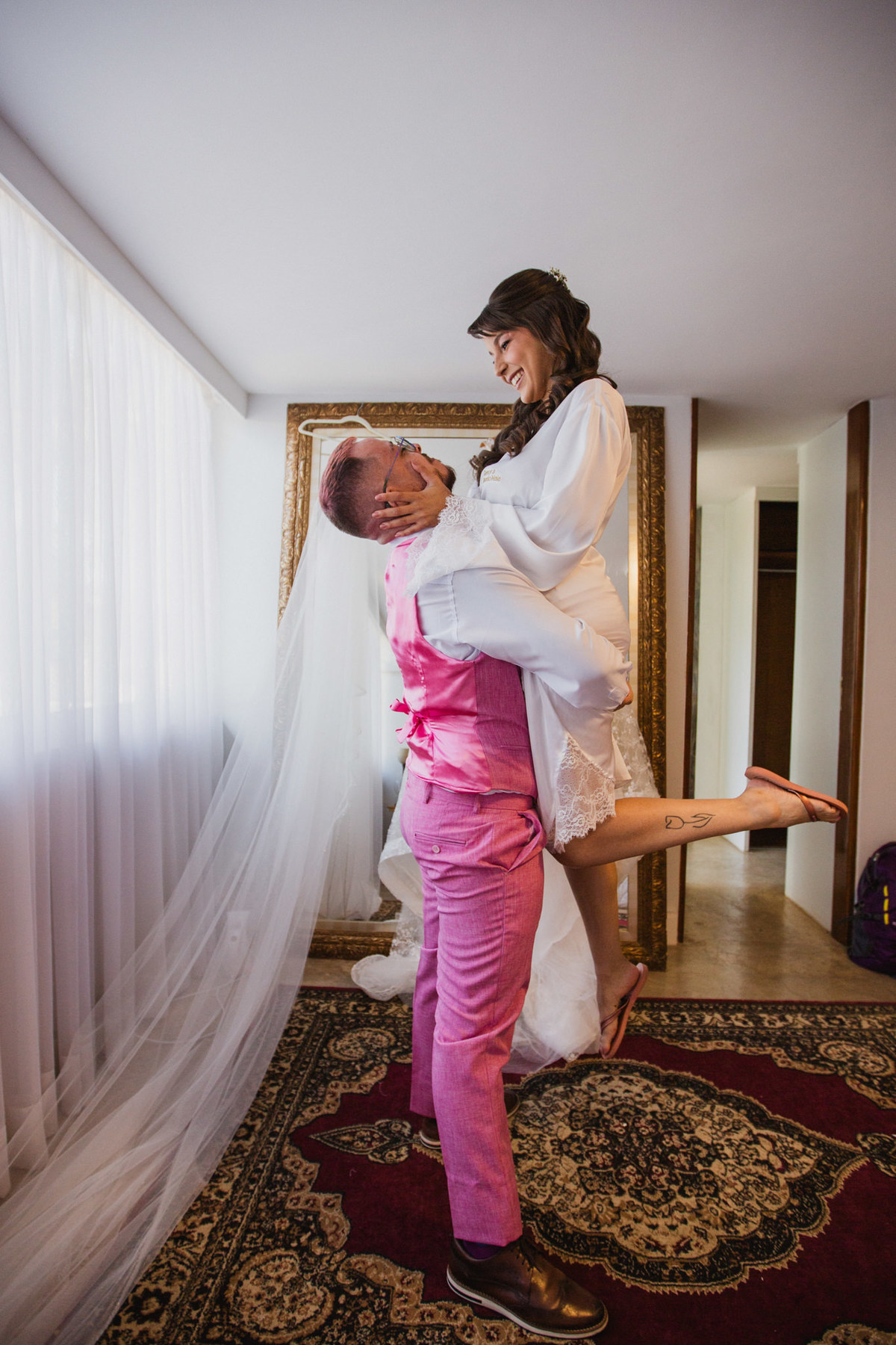 Padrinho levantando a noiva no making of do casamento. Crédito: Fotógrafo de casamento Rafael Ohana feito em Brasília-DF