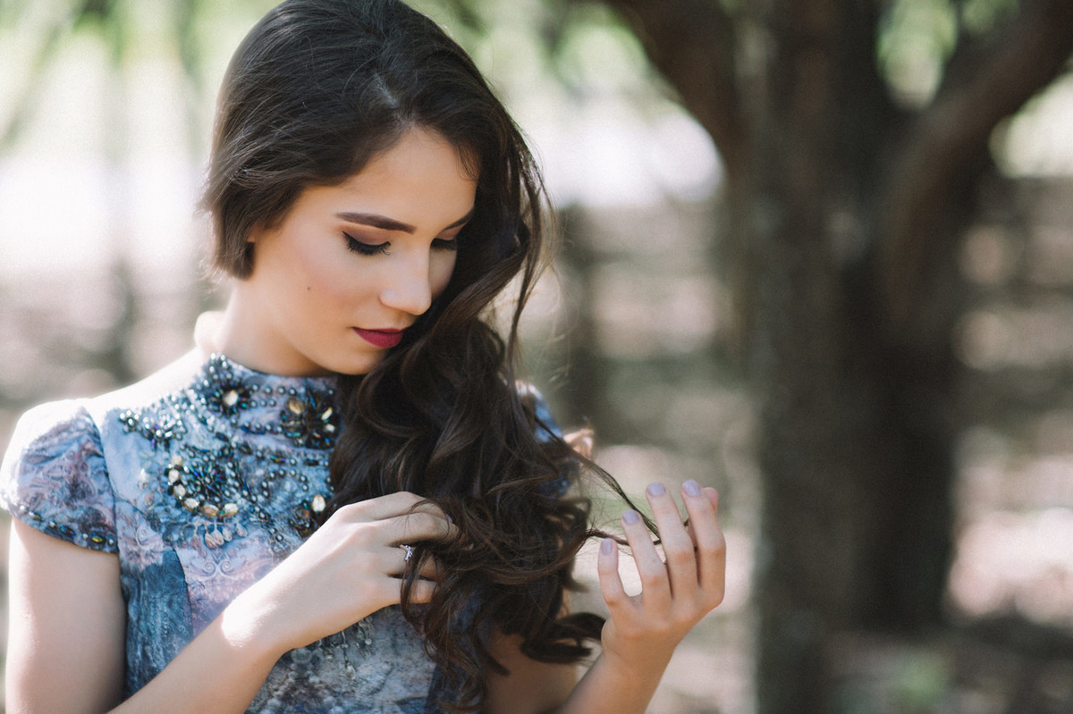 book de 15 anos da menina sara com seu vestido azul na floresta