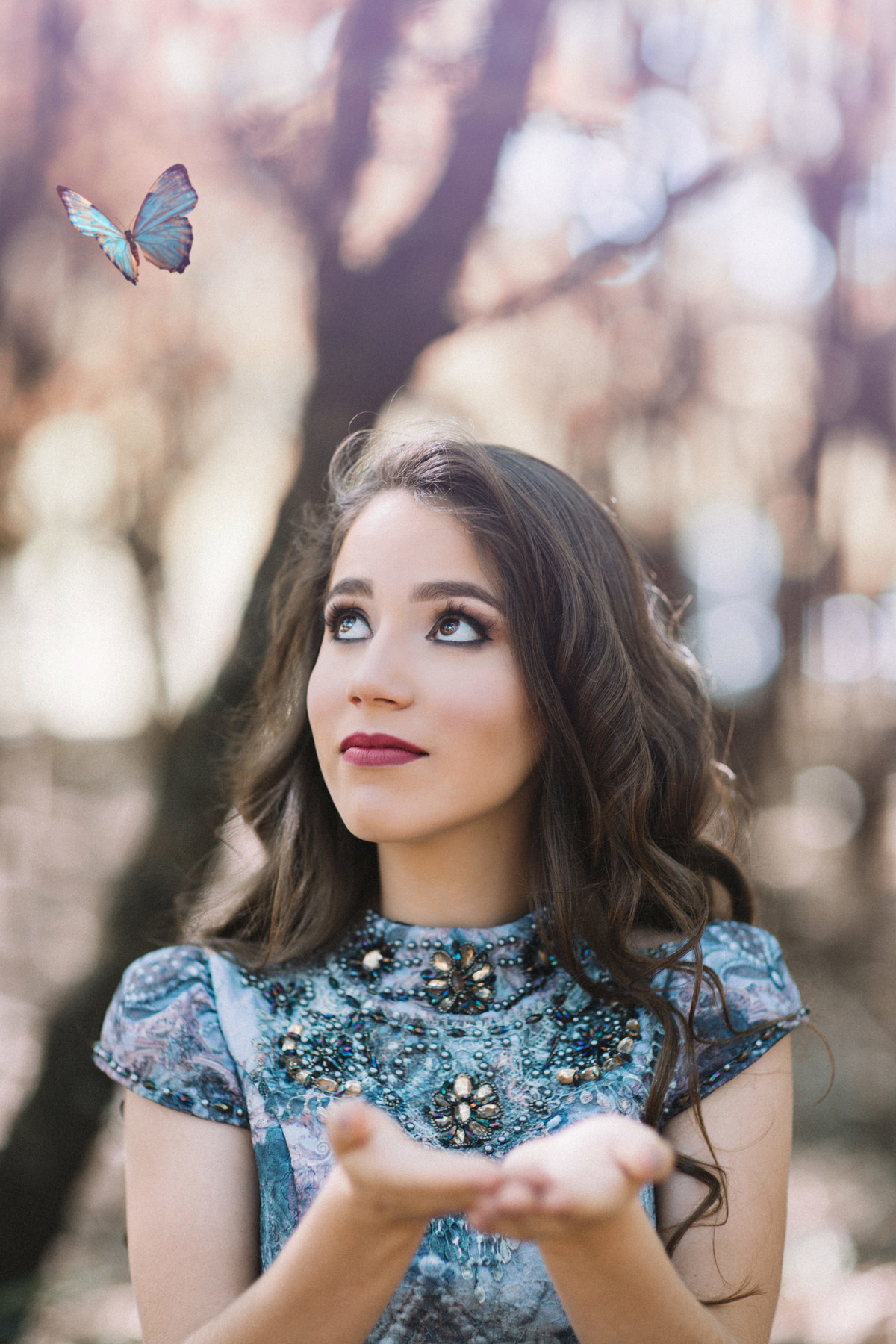 Menina de 15 anos olhando para borboleta na floresta