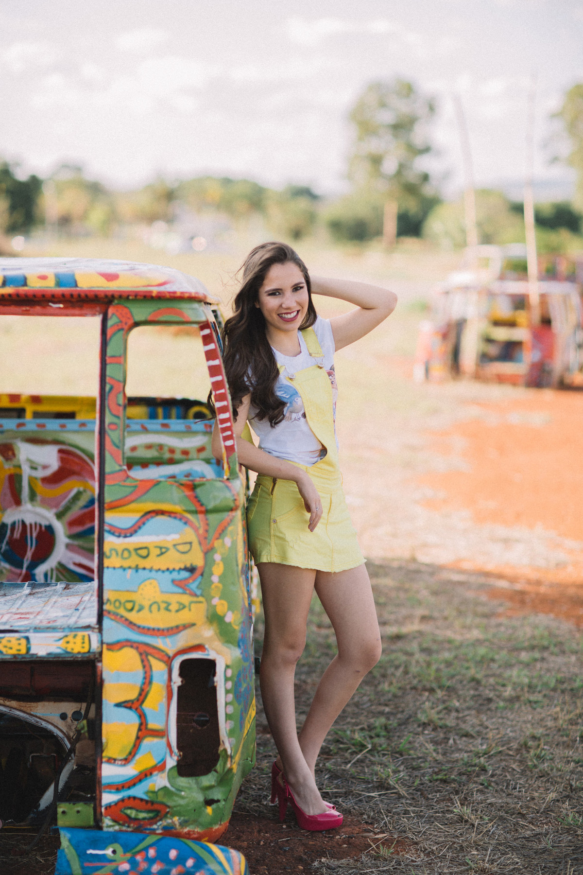 Menina de 15 anos vestindo amarelo encostada em combi