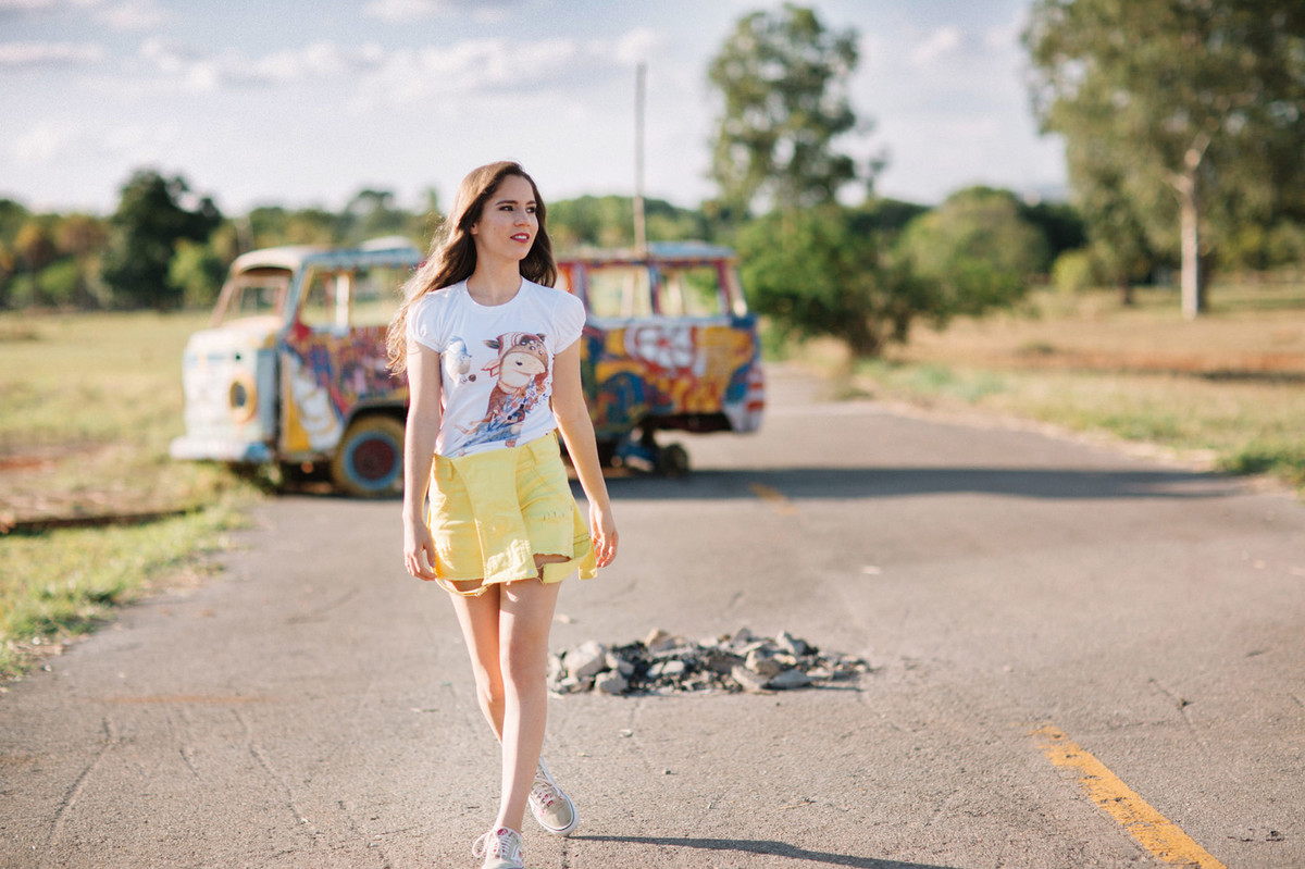 Menina vestindo macacão amarelo andando pela rua