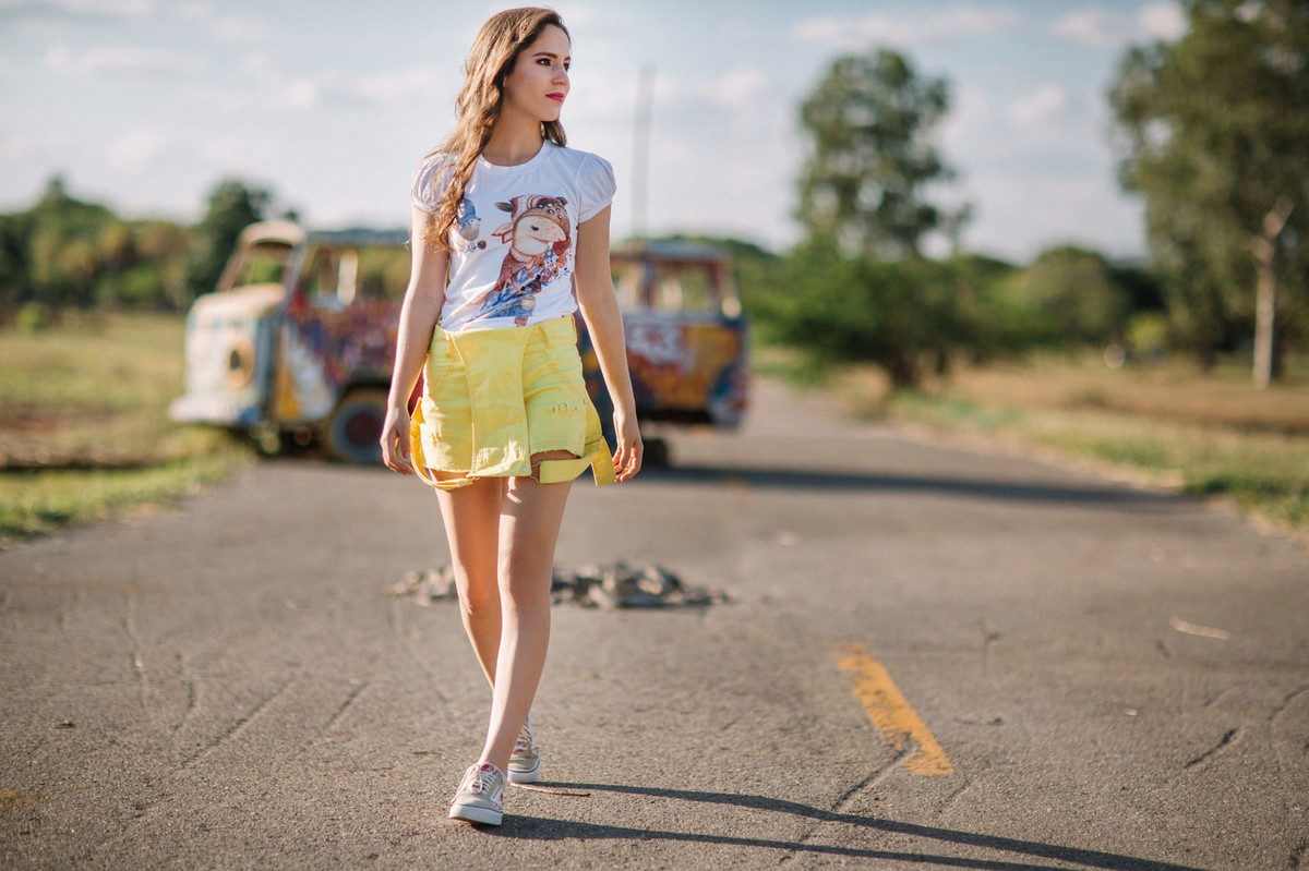 Menina de macacão amarelo andando pela rua