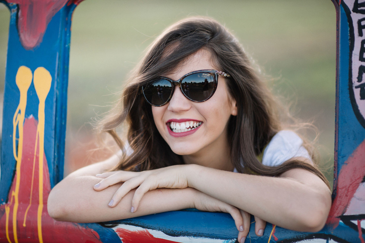 Ensaio fotográfico de 15 anos com menina de oculos escuros rindo
