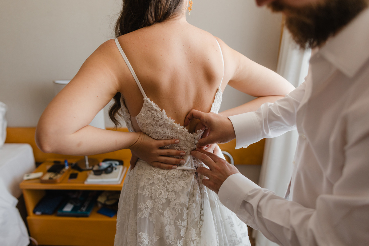 Noivo vestindo a noiva em making of de casamento. Foto feita no hotel Brasília Palace pelo fotógrafo Rafael Ohana