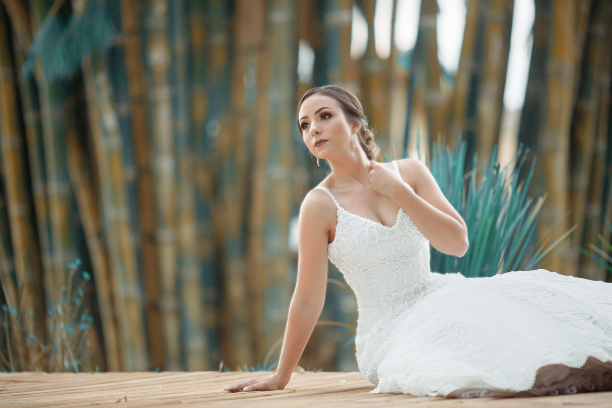 Noiva sentada no chão com a mão no colo. Foto feita pelo fotógrafo de casamento Rafael Ohana