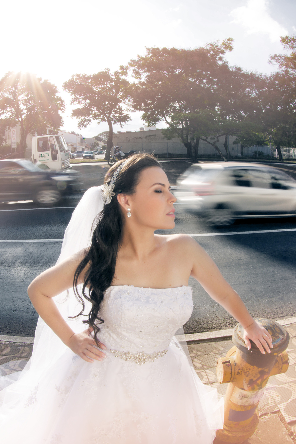 Noiva na beira da pista com carros passando ao fundo. Foto feita pelo fotógrafo de casamento Rafael Ohana 