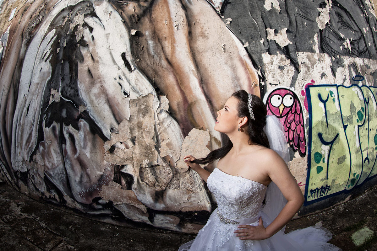 Noiva olhando para parede grafitada. Foto feita pelo fotógrafo de casamento Rafael Ohana