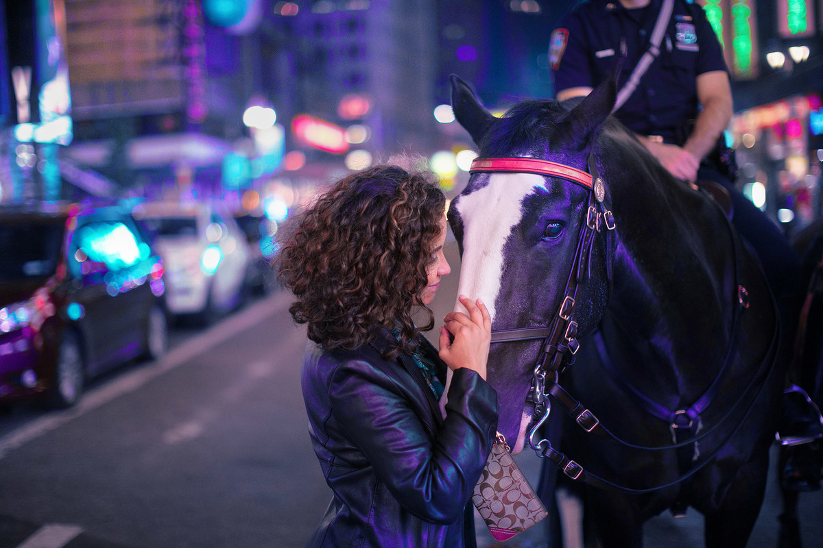 Mulher fazendo carinho em cavalo de policial em Nova York.  Ensaio feito pelo fotógrafo brasileiro Rafael Ohana