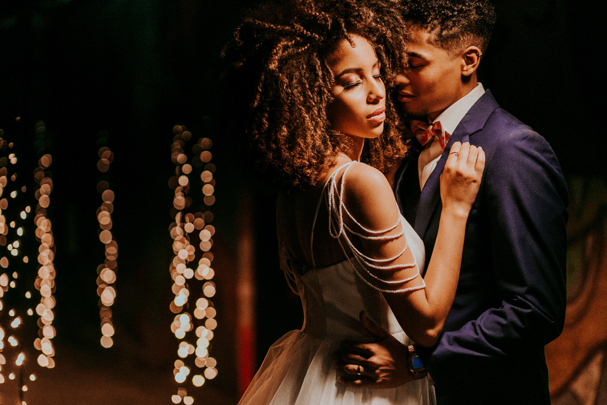 Casal se abraçando perto de cortina de led. Foto feita pelo fotografo de bodas Rafael Ohana em Brasilia