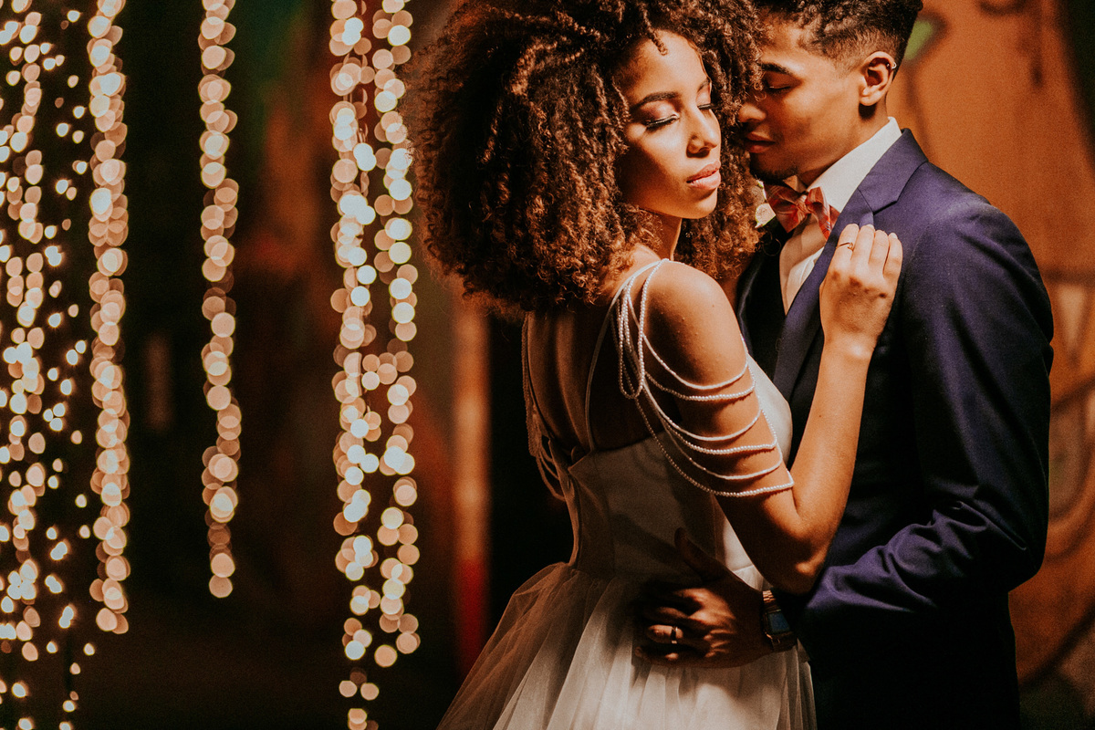 Casal se abraçando perto de cortina de led. Foto feita pelo fotografo de bodas Rafael Ohana em Brasilia