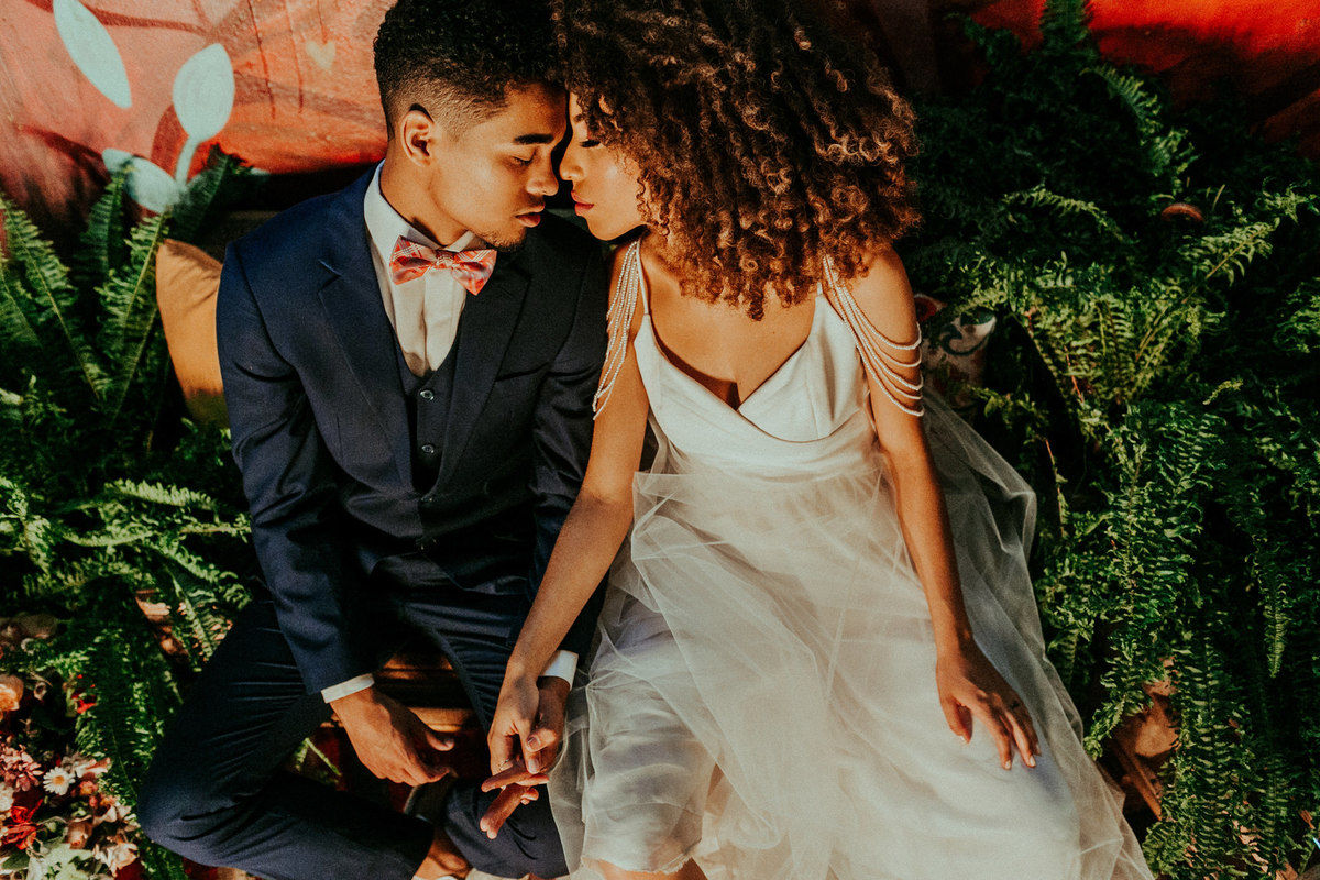 Noivos se amando de olhos fechados segurando as mãos. 